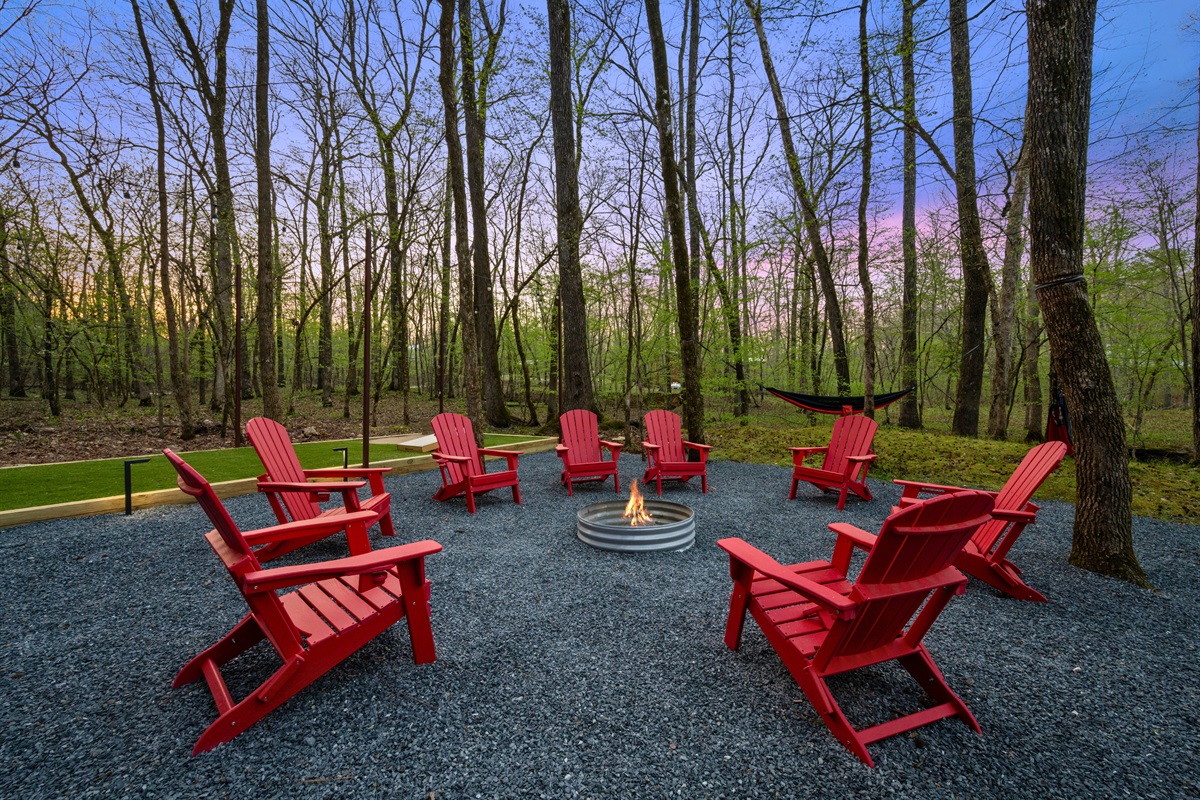 The fire pit area, complete with Adirondack chairs, creates a welcoming space to gather, share stories, and enjoy the evening air.