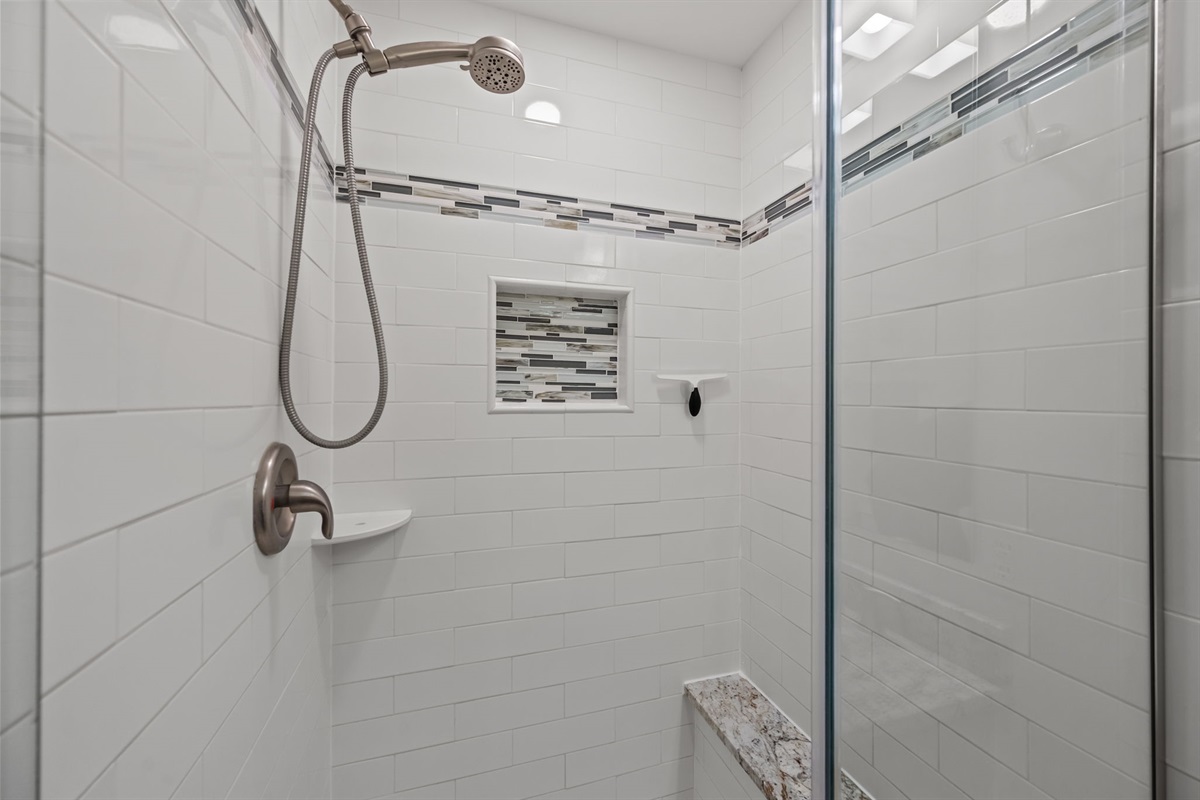 Spacious tiled walk-in shower with built-in niche