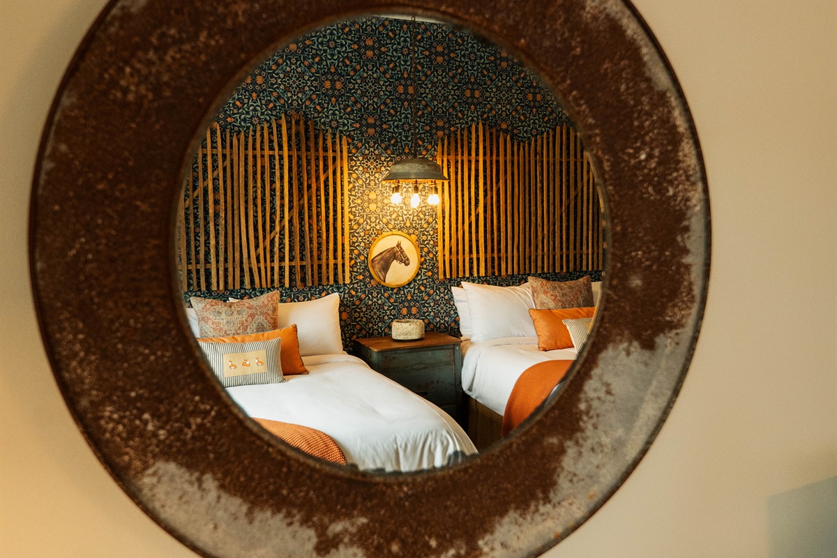 Curated modern Western details at the Corral Suite — designer lighting and a custom bamboo-and-pattern feature wall.