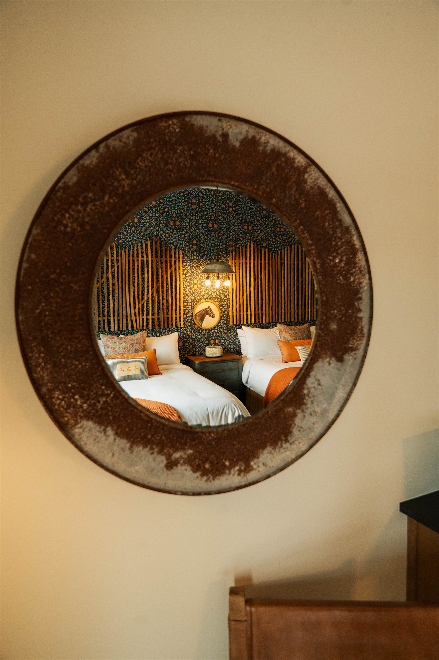 Curated modern Western details at the Corral Suite — designer lighting and a custom bamboo-and-pattern feature wall.