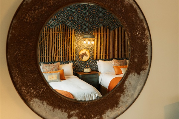 Curated modern Western details at the Corral Suite &mdash; designer lighting and a custom bamboo-and-pattern feature wall.