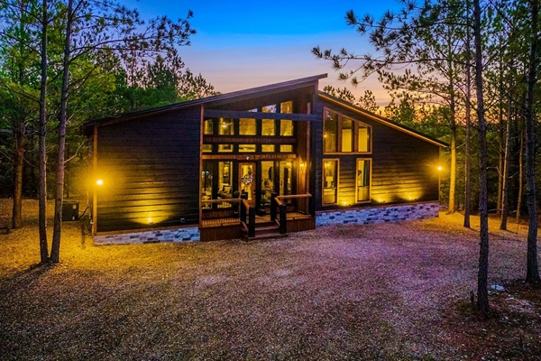 Front View of the Cabin: Experience rustic charm surrounded by nature at sunset!