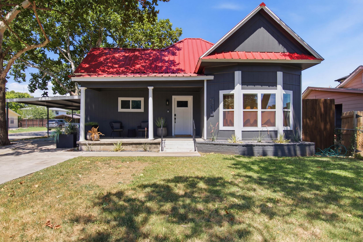 Bright exterior with a striking red roof and inviting porch for relaxing afternoons!