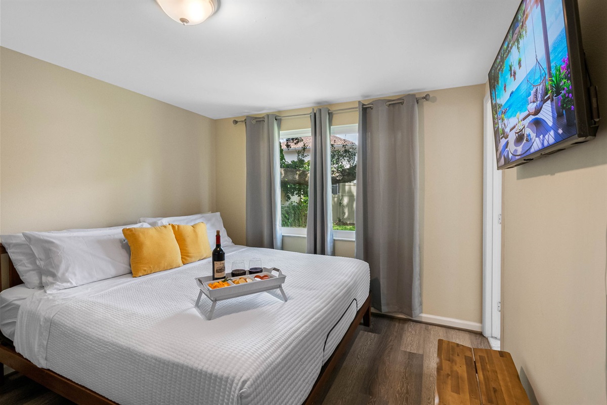 The room is tastefully styled with neutral walls and rich wood-look flooring, which enhance the clean and tranquil ambiance.