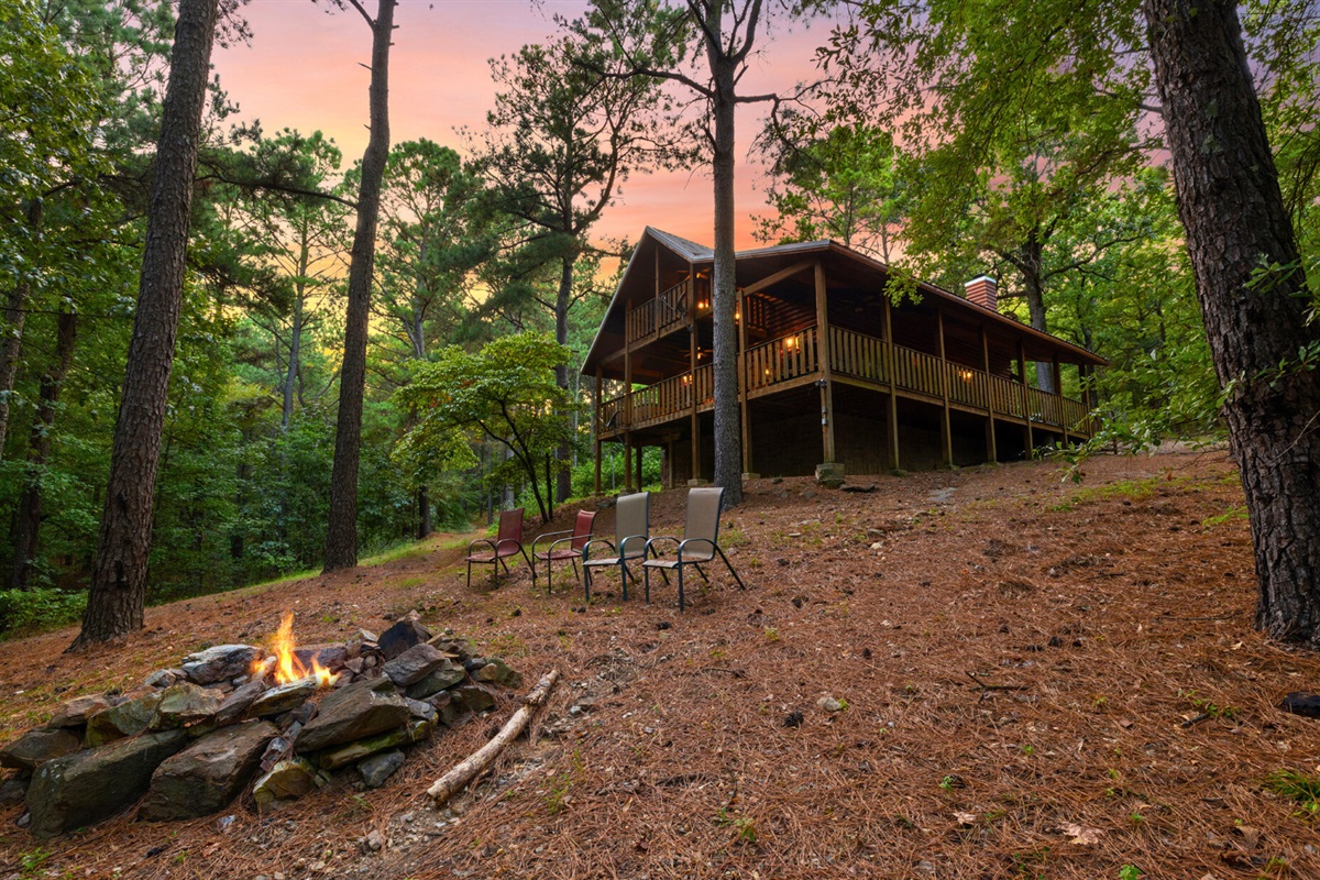Cabin view with fire pit ready for stories and s’mores.