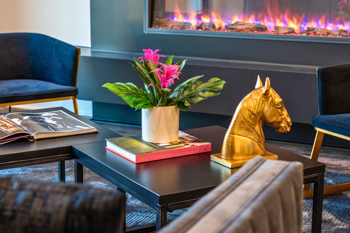 This thoughtfully styled coffee table adds a touch of artistry to the living room, combining bold decor with an inviting and elegant vibe.