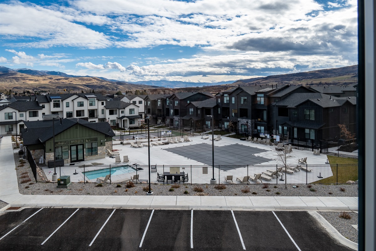Pool-view balcony overlooking resort-style amenities.