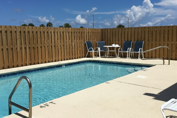 Enjoy exclusive access to this inviting pool area, complete with comfortable seating and a privacy fence for your ultimate enjoyment.