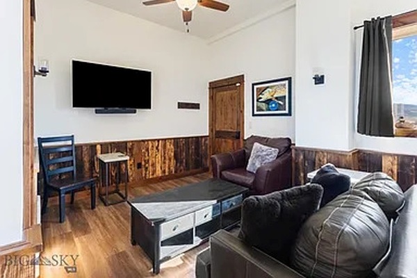 Living room area with smart tv and leather sofa sleeper.