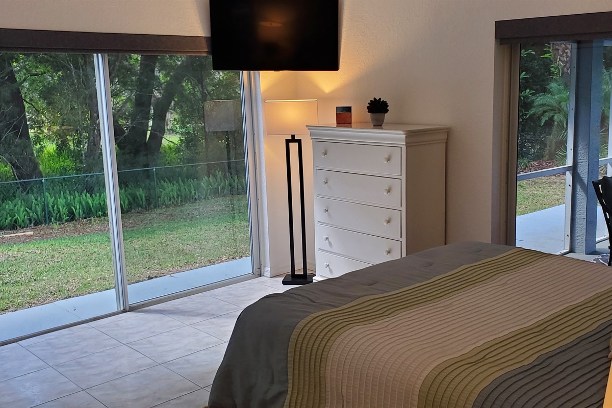 Master Queen bedroom with smart TV and access to backyard and lanai