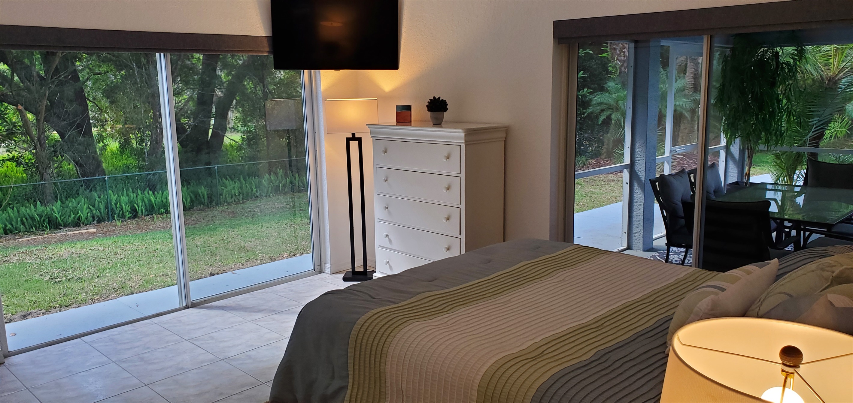 Master Queen bedroom with smart TV and access to backyard and lanai