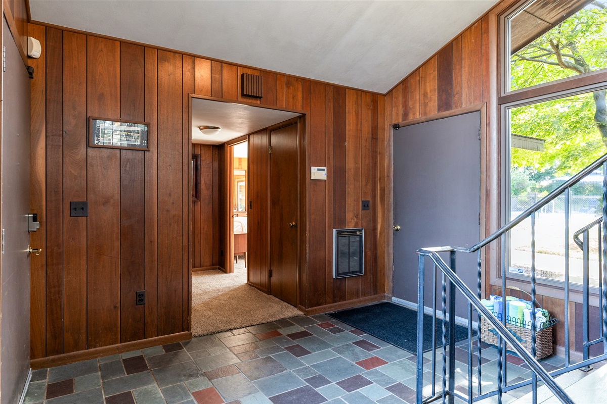 Functional entry hallway with rich wood tones and direct access to the heart of the home.