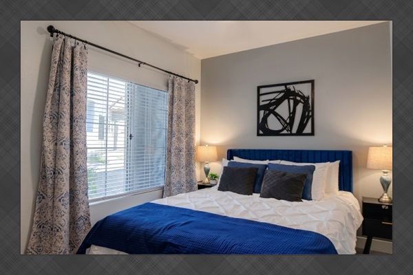 - Serene bedroom with soft linens, blue accents, and natural light   - Large window brings in warmth and peaceful outdoor views   - Designed for rest, comfort, and a cozy night’s sleep