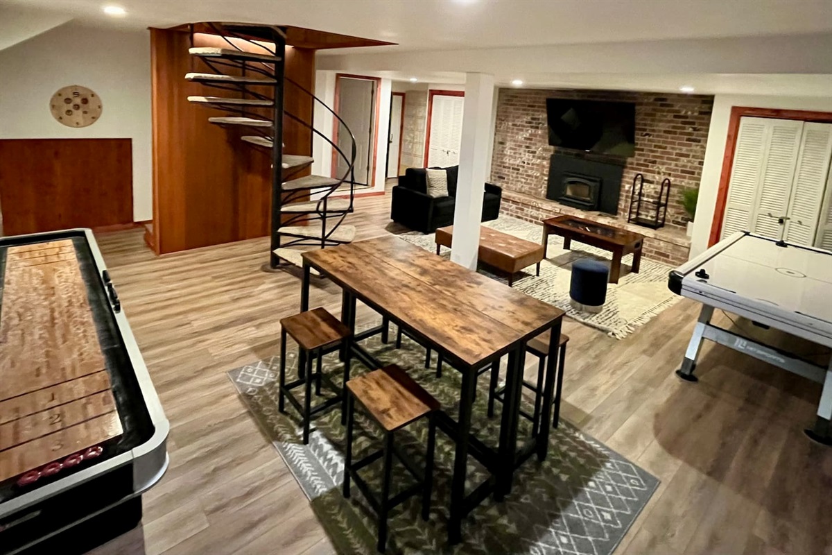 Mount Hood and Winter Sports Themed Game Room with Wood Burning Fireplace and Large Smart TV.