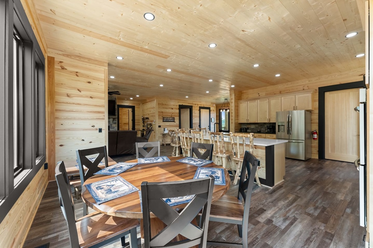 This round wood dining table offers an intimate setting for meals, board games, or morning coffee—right beside the open-concept kitchen and living room.