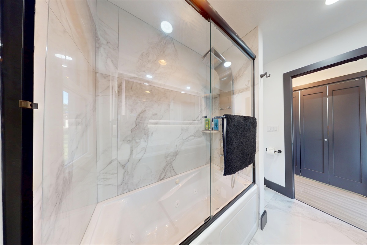 Upper-level bathroom is a tub/shower combination with a full-body sprayer and a railhead.