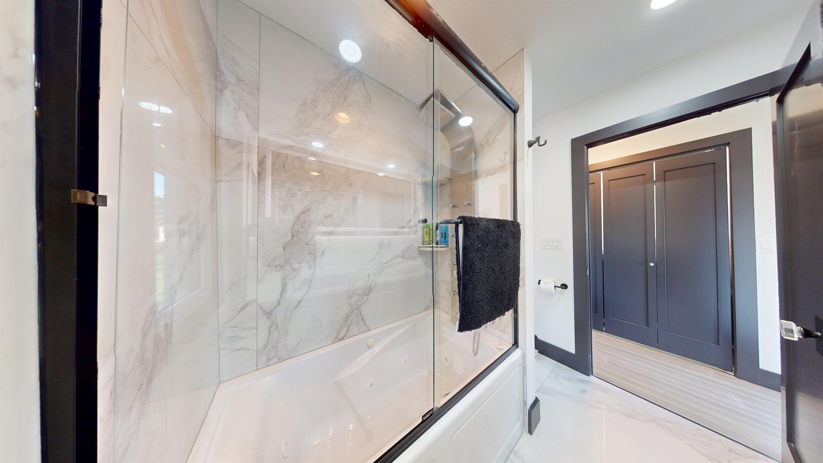 Upper-level bathroom is a tub/shower combination with a full-body sprayer and a railhead.