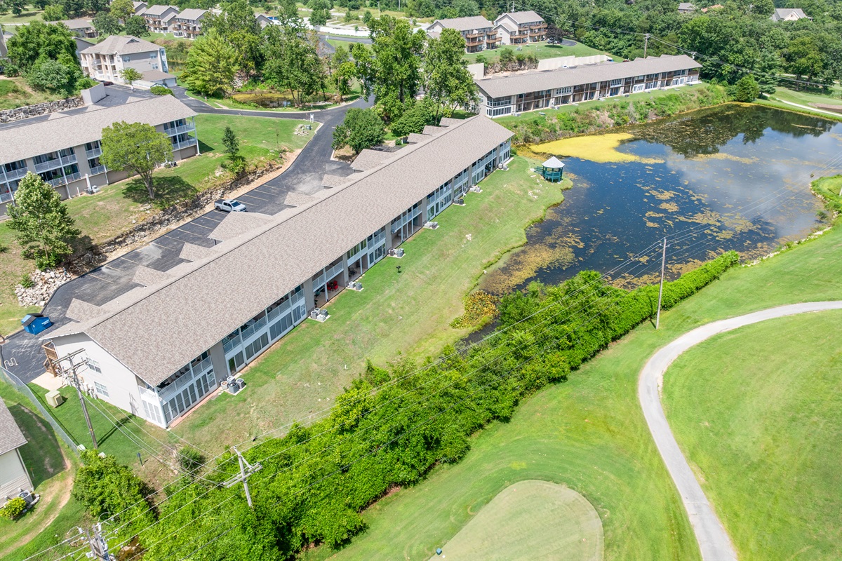 Another aerial perspective shows how the condo sits near water, trees, and the surrounding neighborhood.