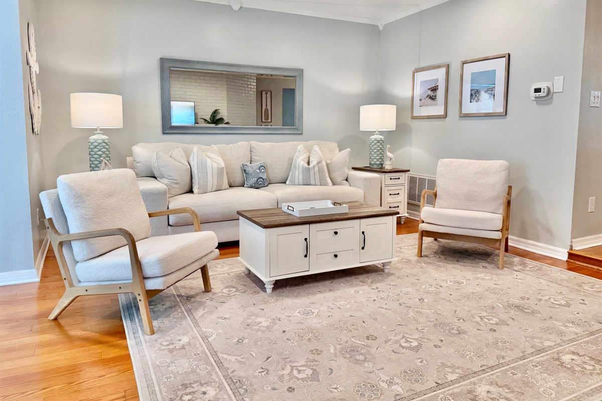 This light-filled living room offers plush seating, a large smart TV, and coastal-chic decor that sets the tone for a relaxing stay.