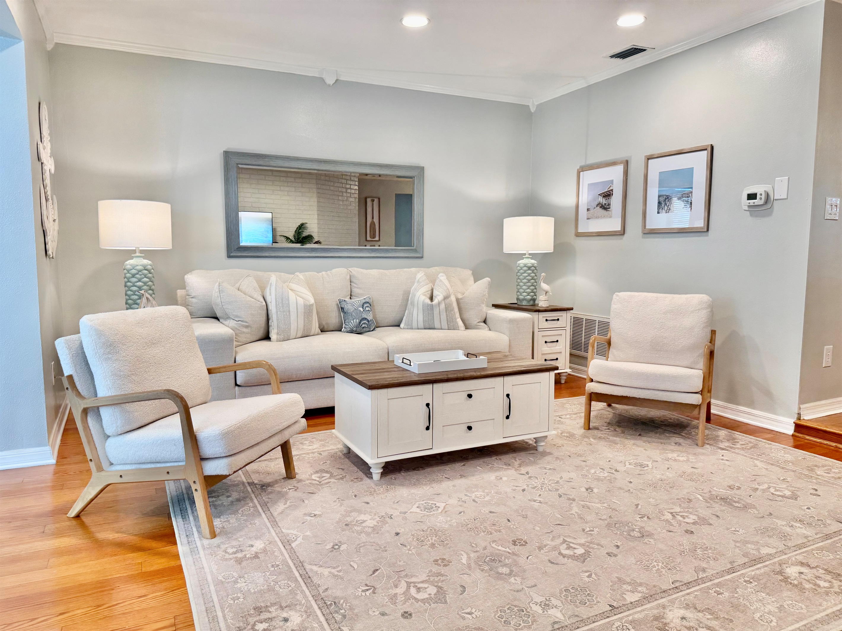 This light-filled living room offers plush seating, a large smart TV, and coastal-chic decor that sets the tone for a relaxing stay.