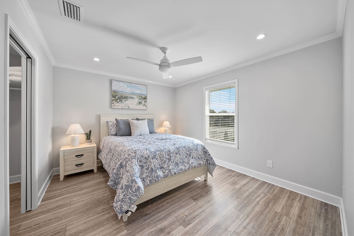 Master bedroom of Unit A with a queen bed and half bathroom. 