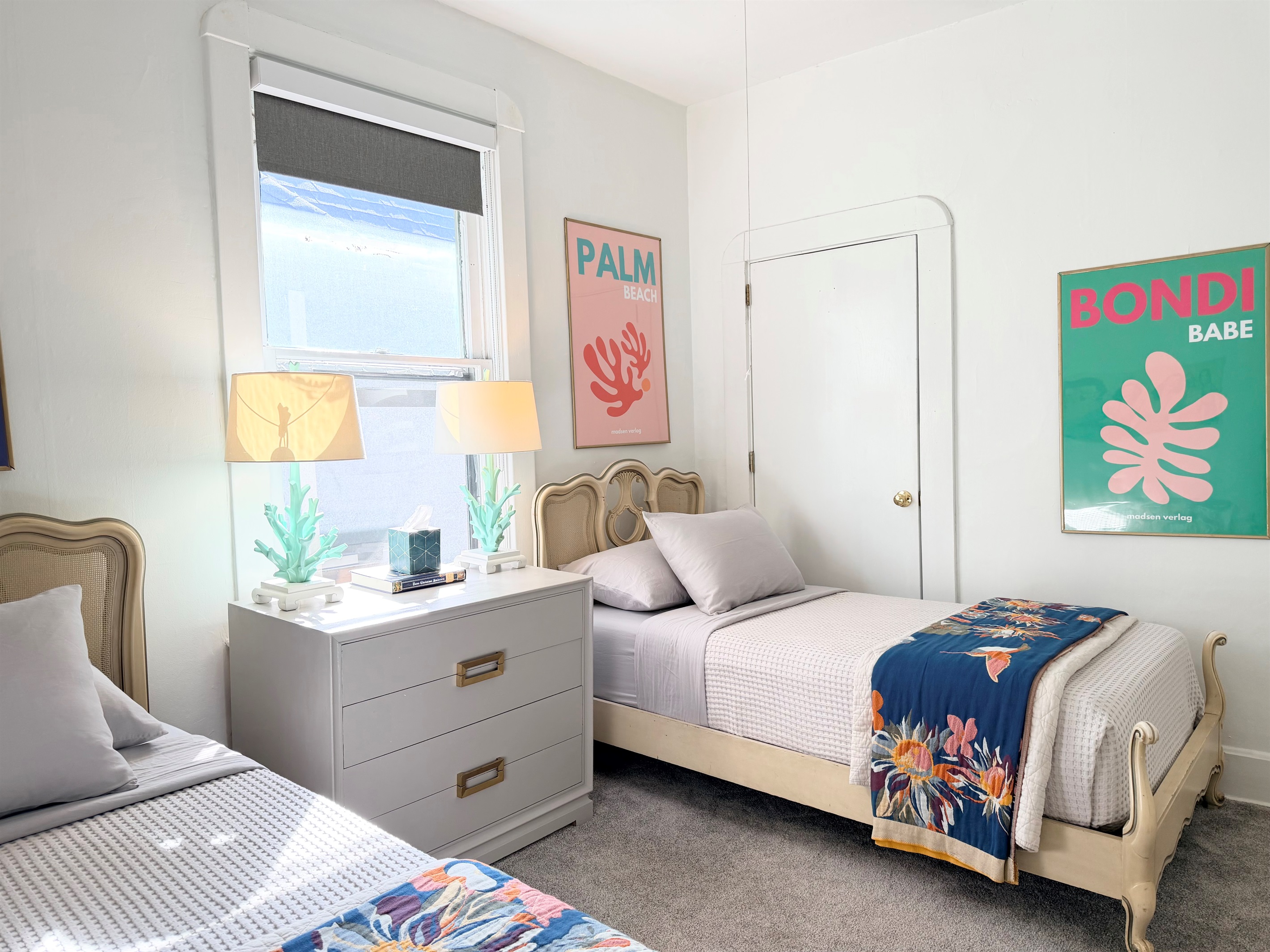 Bright and airy twin bedroom with an easy layout and open garment racks at the foot of each bed — ideal for shared stays, families, or extended visits.