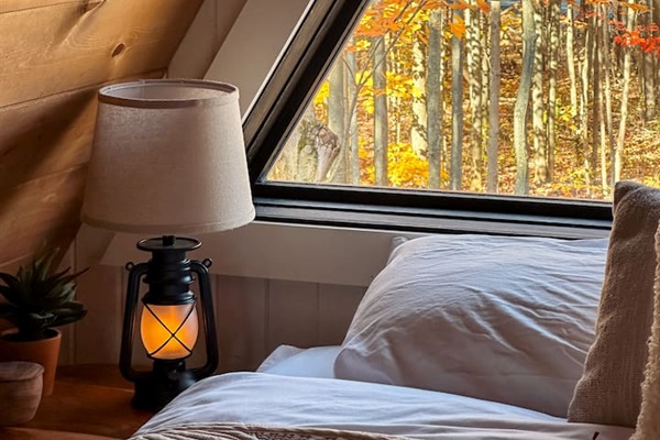 This dreamy second-story loft is accessible only by a ship’s ladder, adding an adventurous yet intimate feel. It features a king bed beneath a dramatic A-frame ceiling. Large triangular windows offer stunning views, making it the perfect hideaway.