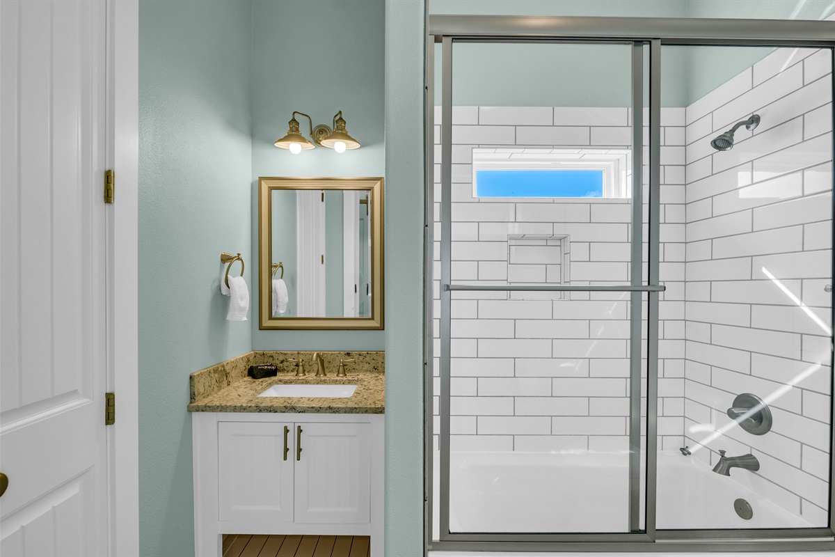 Sea It All: Guest bathroom that services all guests in the twin bunk room, single vanity, shower/tub combo, and closet for storage. 