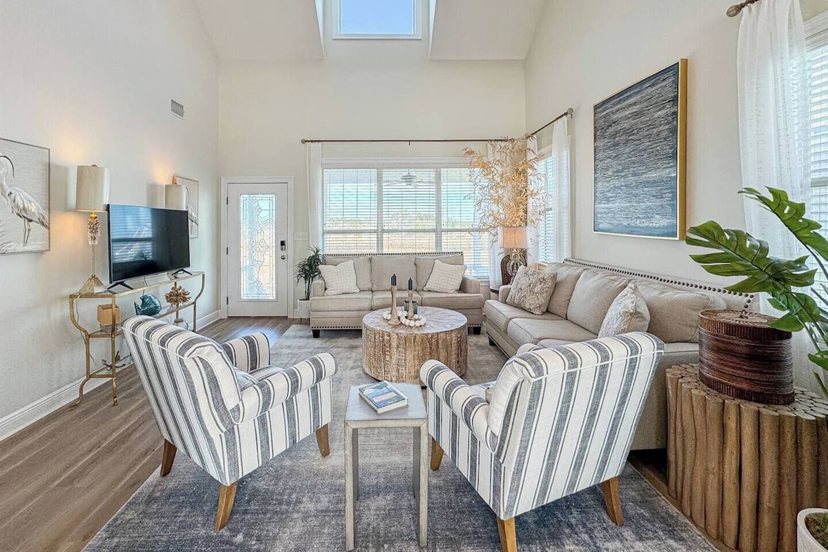 Inviting living room with plush sofas, stylish decor, and plenty of natural light in a spacious, open-concept setting.