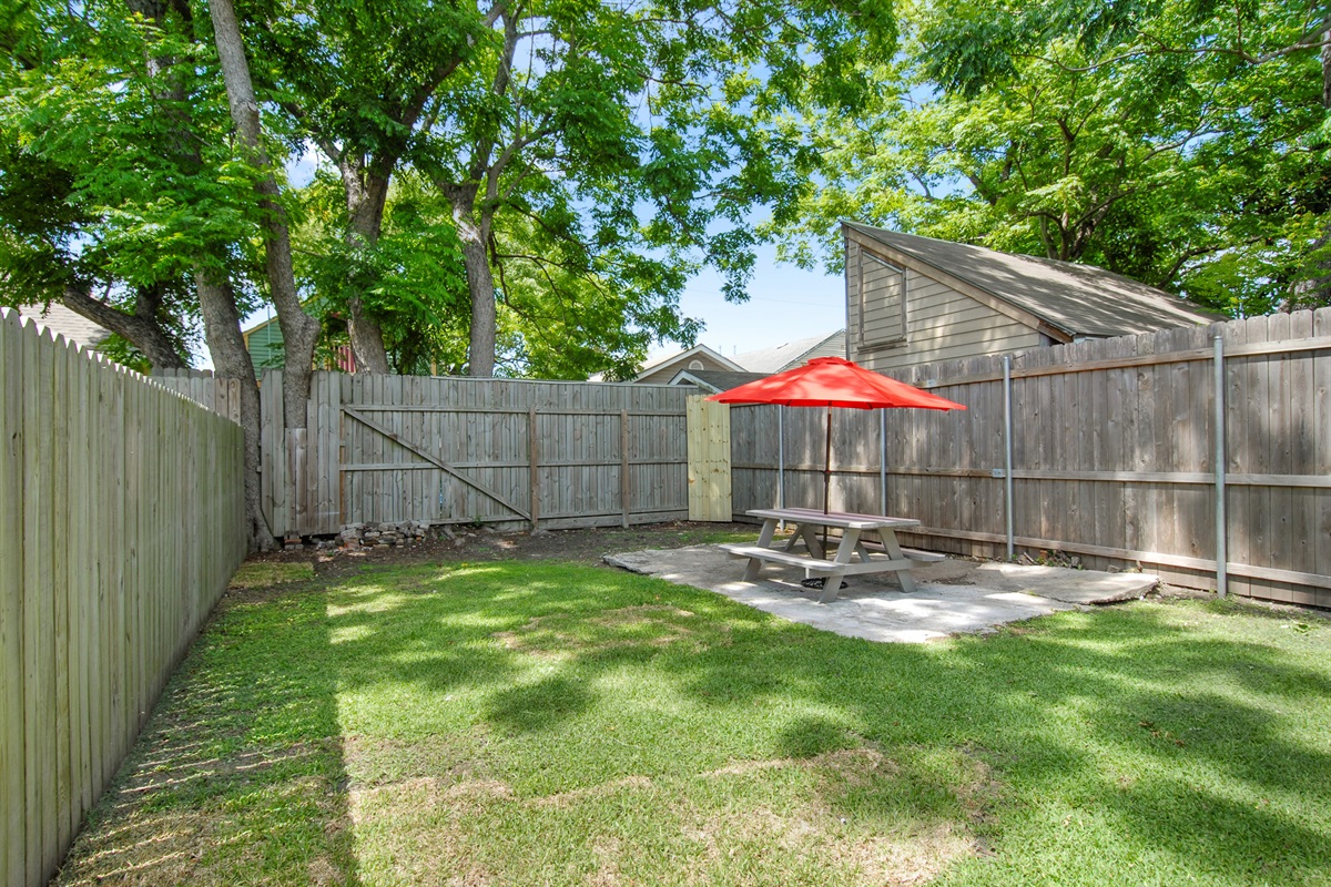 Backyard shared with neighboring guests.  Seating and charcoal grill.