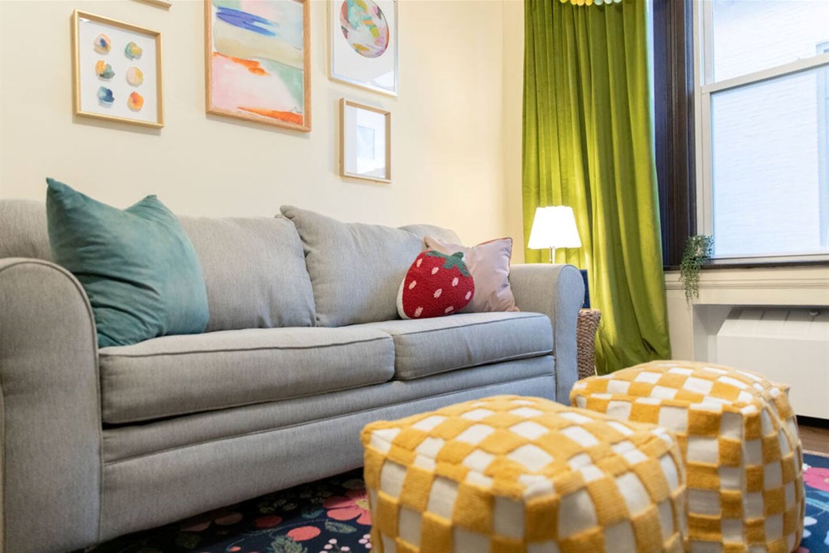Bright and spacious living room featuring a comfortable sofa bed, perfect for relaxing or accommodating extra guests.