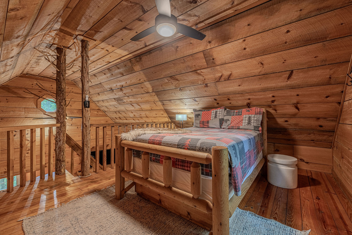 Big loft bed under vaulted wood ceilings.