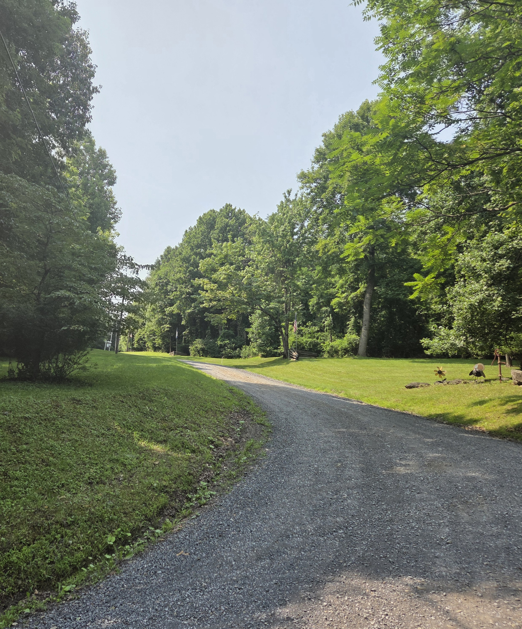 The property is accessed by a winding gravel mountain road with hills and curves.