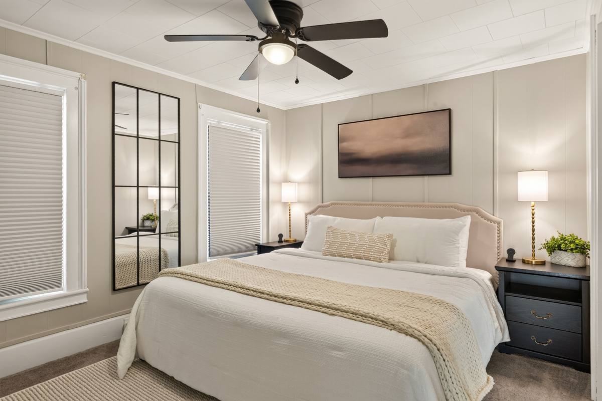 Bedroom with ceiling fan and wall art