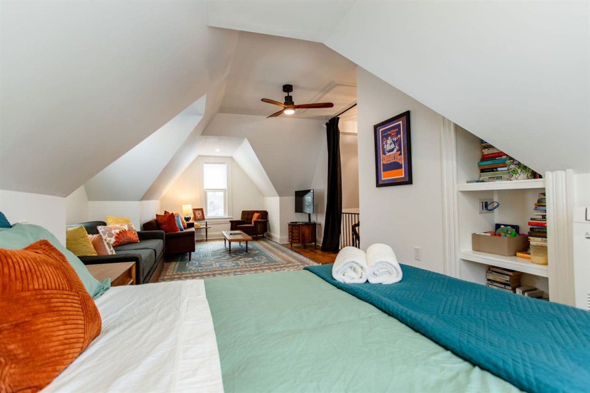 A bedroom with an integrated living area, featuring a cozy seating space with a sofa or armchairs, creating a multifunctional room for relaxation and comfort.