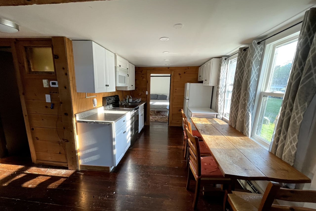Kitchen seen from living room. Door from kitchen opens to bedroom with queen bed.