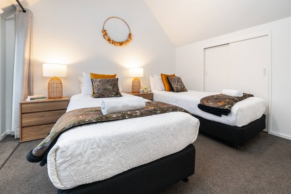 Morning light pours into this upstairs bedroom, where the balcony adds fresh air and a direct connection to Fernhill’s mountain outlook.