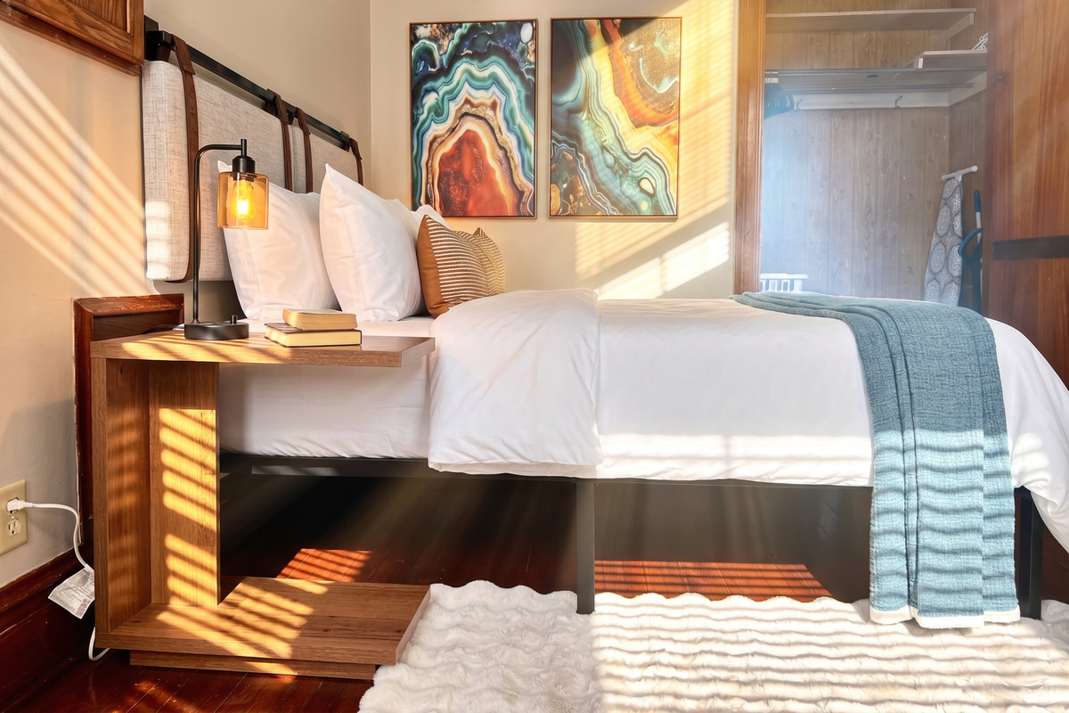 Dimming bedside lamps with usb ports, quality linens and blankets, and a cozy faux rabbit rug will have you feeling relaxed in no time!
