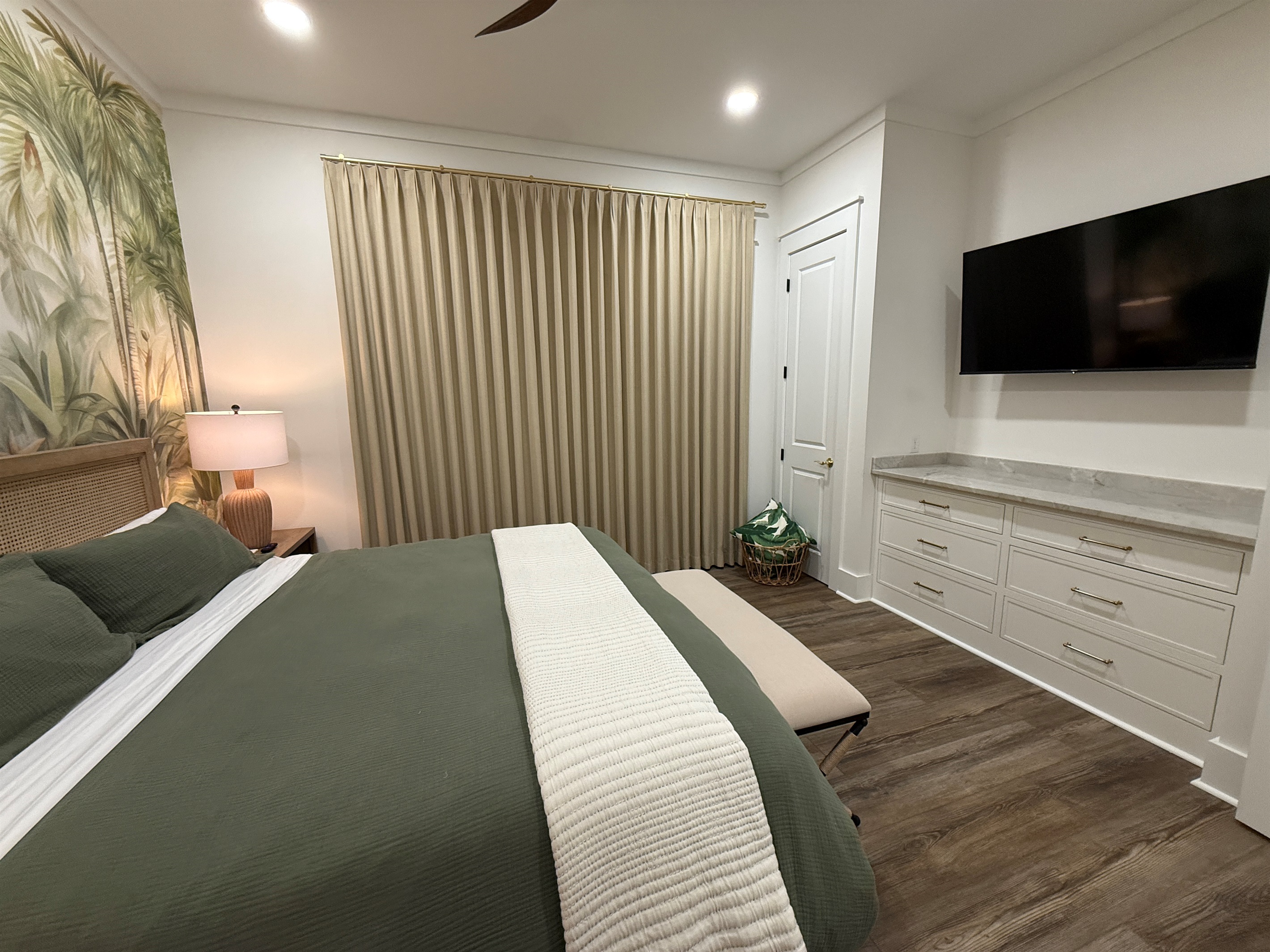 Downstairs master with blackout drapery, 55-inch TV, built-in dresser