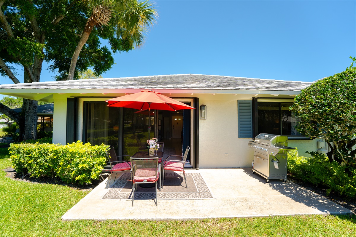 Private lakeside patio with outdoor dining, umbrella, and grill—perfect for morning coffee or sunset meals by the water
