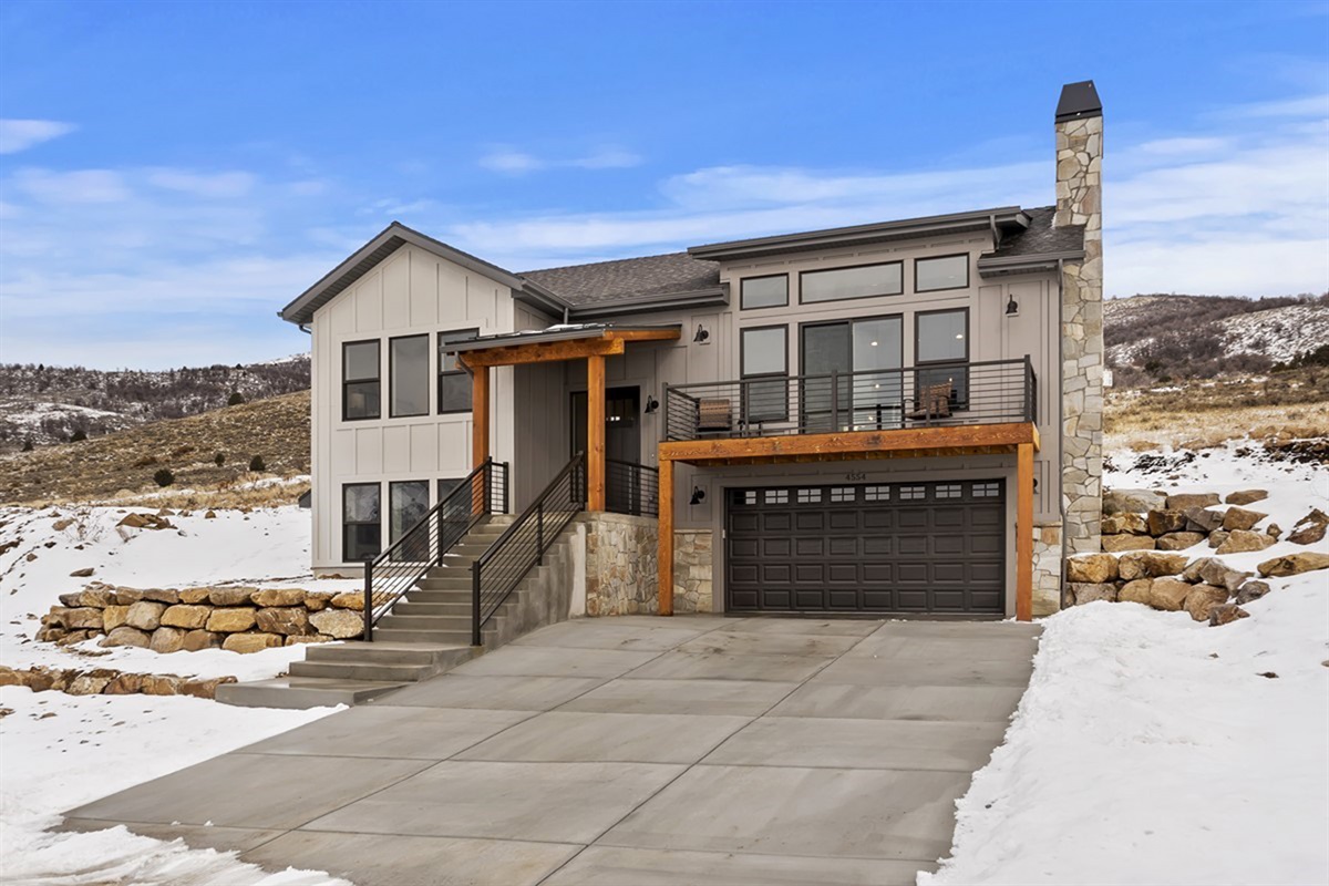 Front exterior in winter showing the home’s striking modern architecture