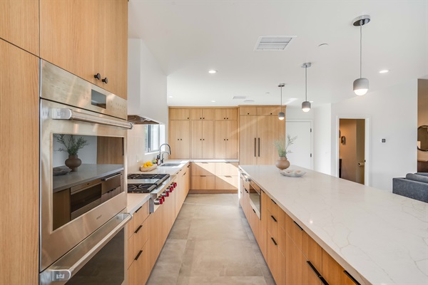 Chef's kitchen equipped with Subzero panel refrigerator/freezer and Wolf appliances including 6-burner range-top and infrared griddle, Professional Series built-in double-ovens, warming drawer