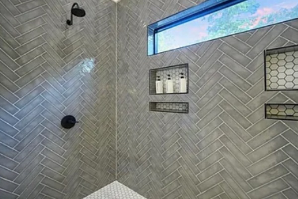 Modern walk-in shower with elegant tile work and built-in niches.