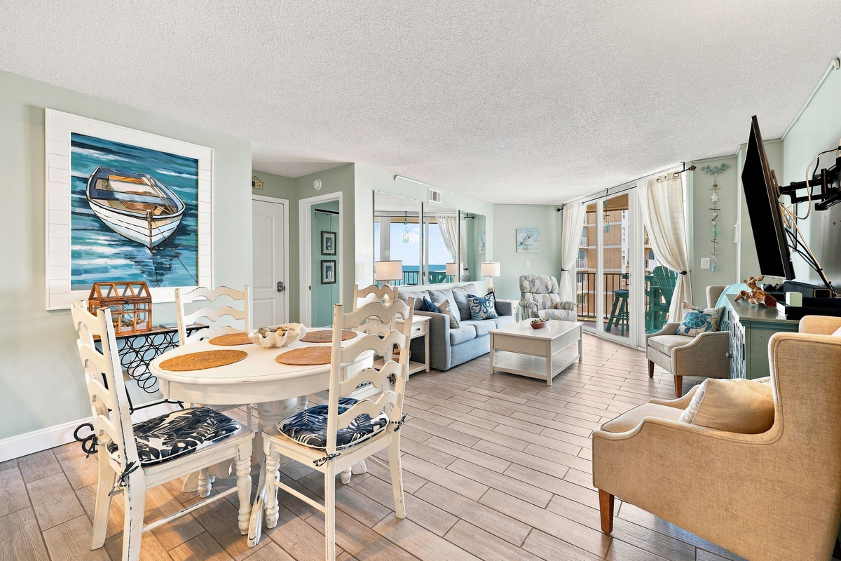 Open living space featuring beachy decor, wood-look tile flooring, and plenty of natural light.