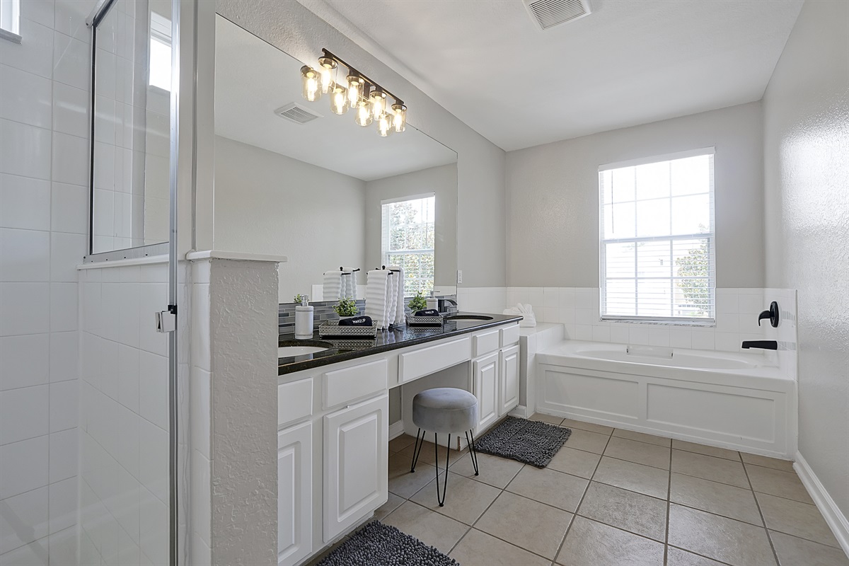 The ensuite Cinderella bathroom features a double vanity, extra large mirror with makeup stool, soaker tub, large shower, and seperate toilet room.