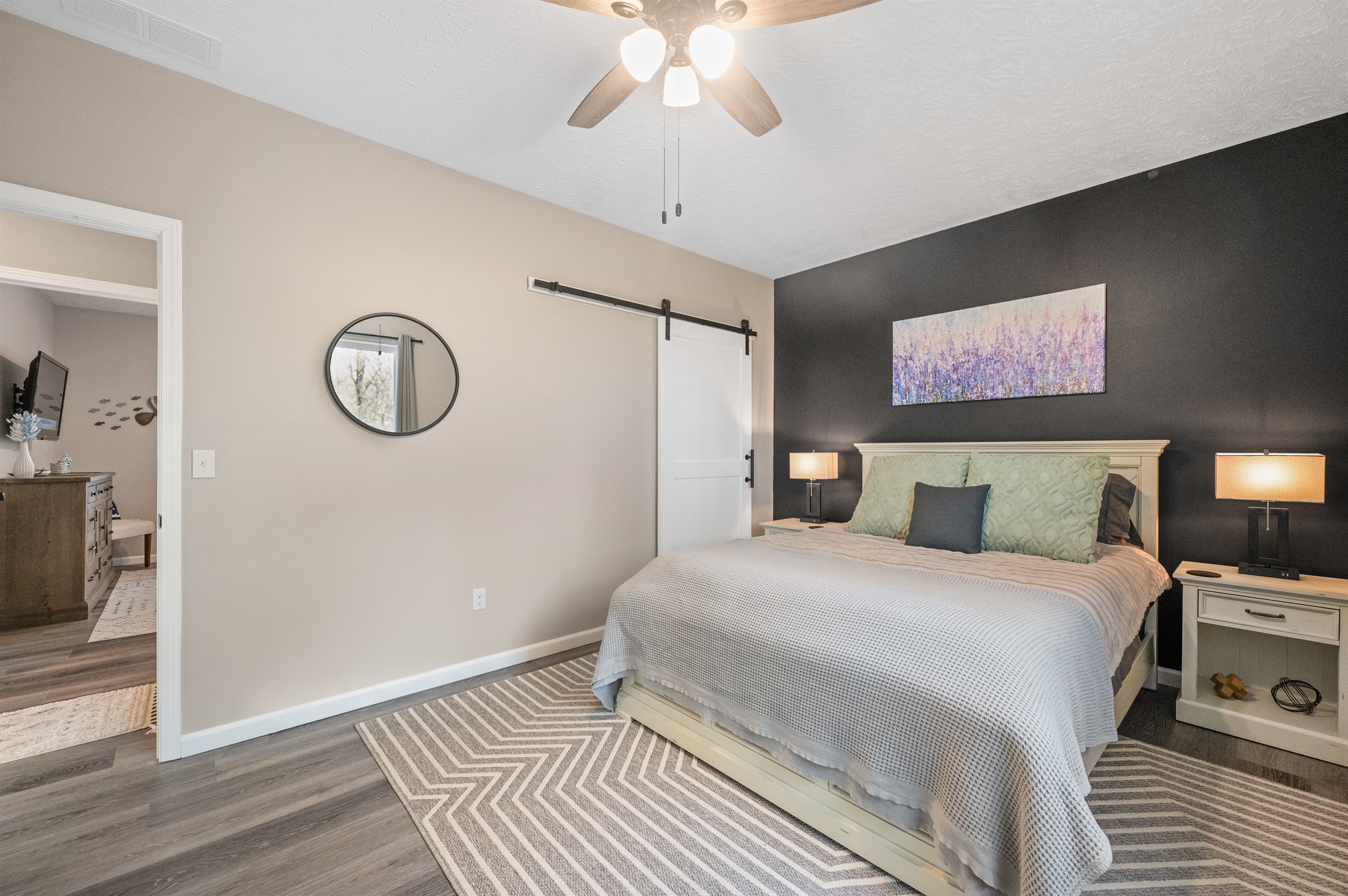 The queen room includes a spacious walk-in closet with a sliding barn door, hangers, luggage racks, and wire shelving to keep your belongings organized during your stay.