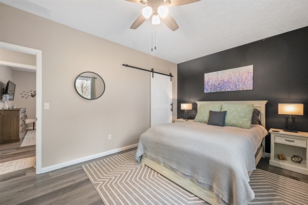 The queen room includes a spacious walk-in closet with a sliding barn door, hangers, luggage racks, and wire shelving to keep your belongings organized during your stay.