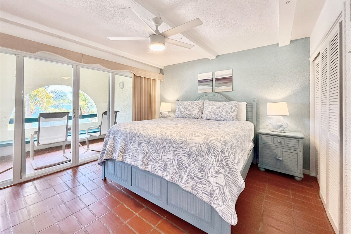 Primary bedroom with balcony, ceiling fan and ensuite bathroom