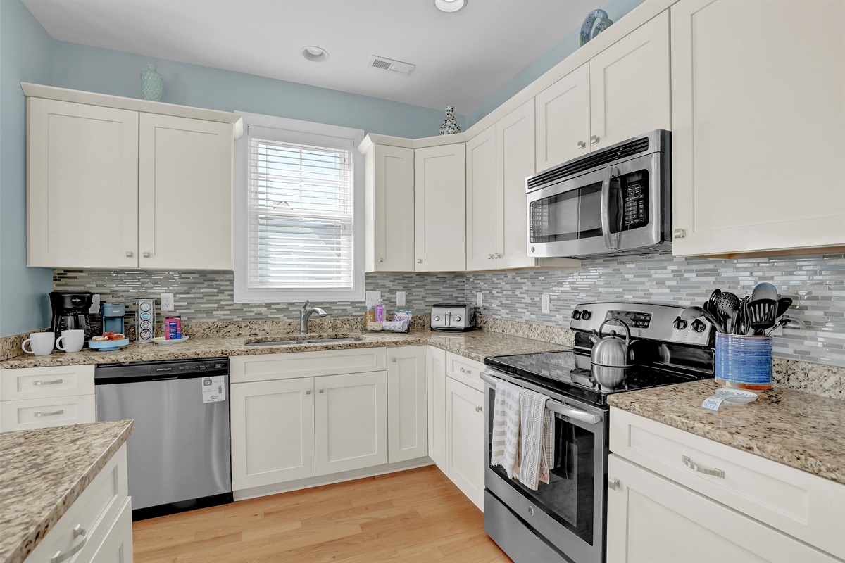Fully equipped chef’s kitchen featuring stainless steel appliances and ample prep space.