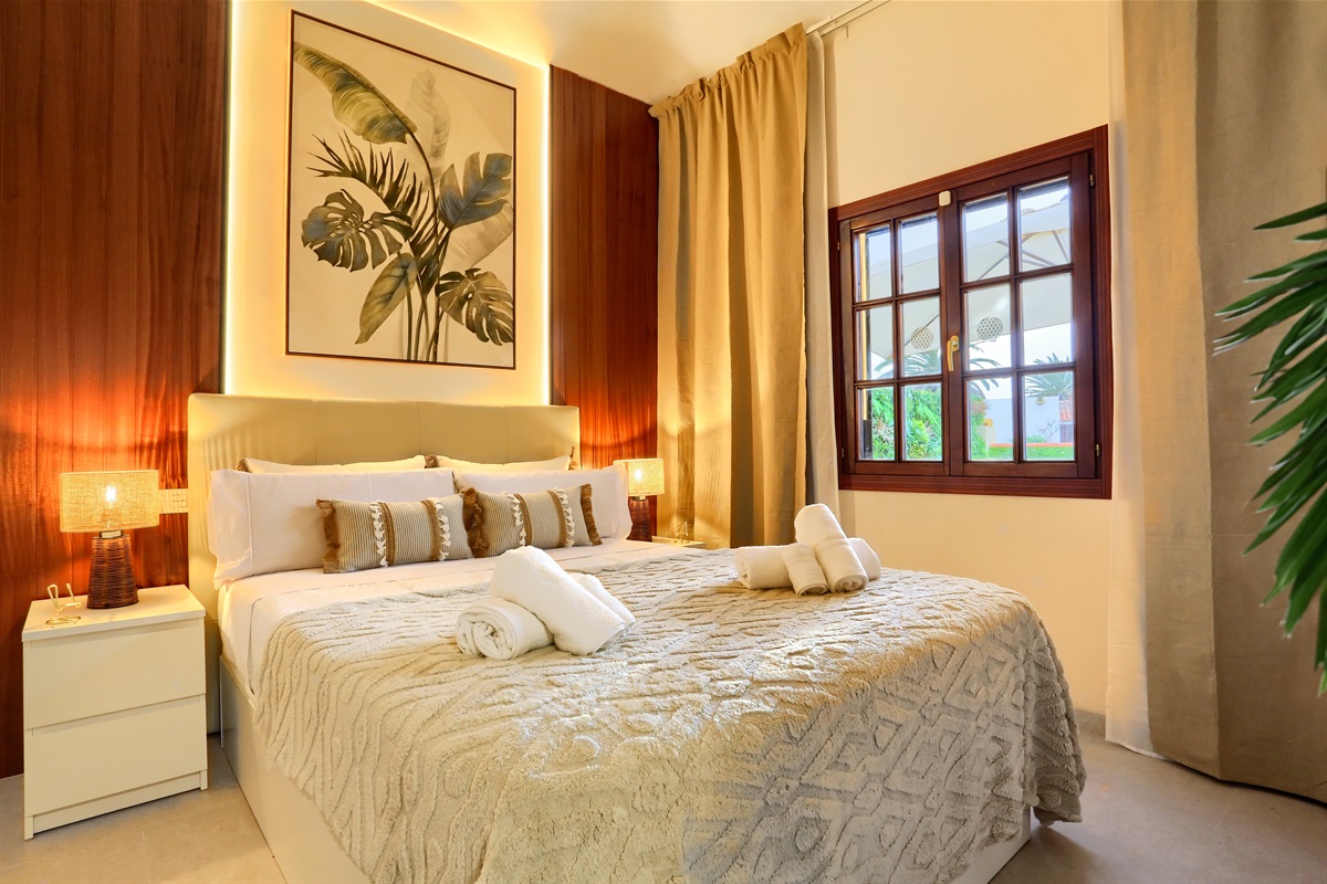 Elegant master bedroom with a double bed, tasteful décor, and a cosy atmosphere - a space designed for rest and comfort during your stay in Fuerteventura.
